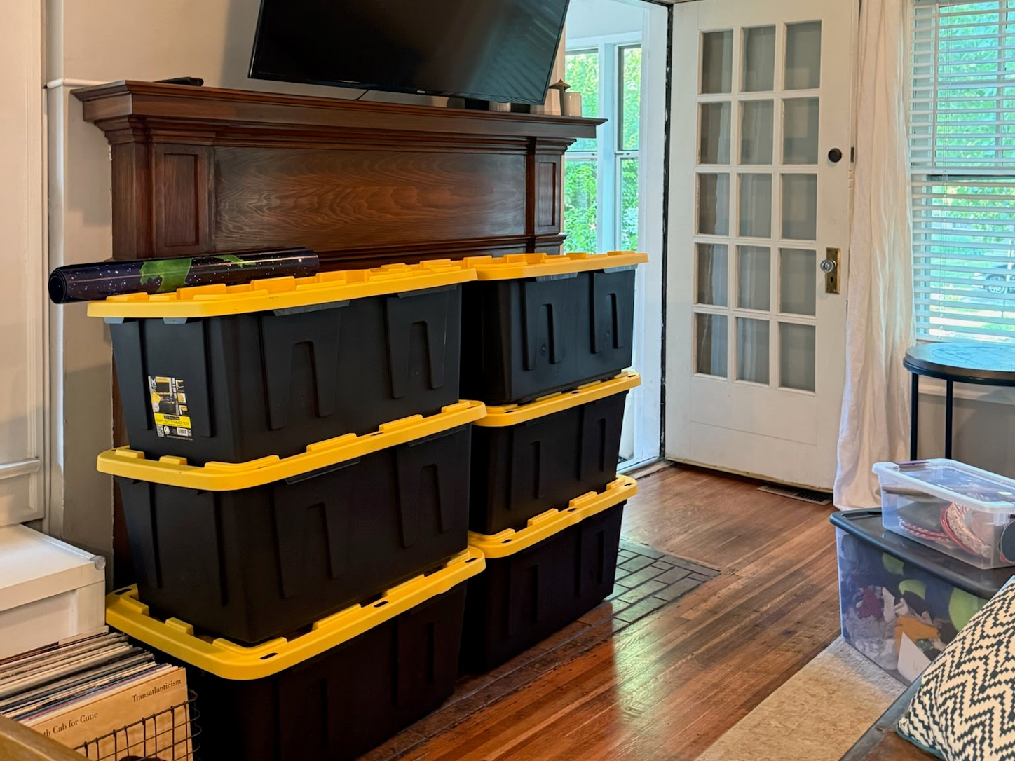 Reusable moving totes stacked in a living room during a move